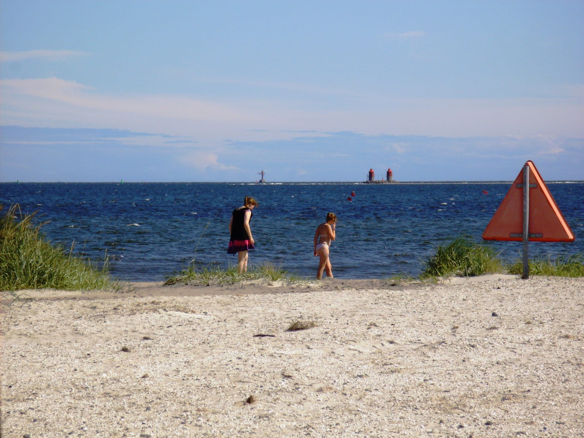 Folk nyder stranden ved havet i solskin