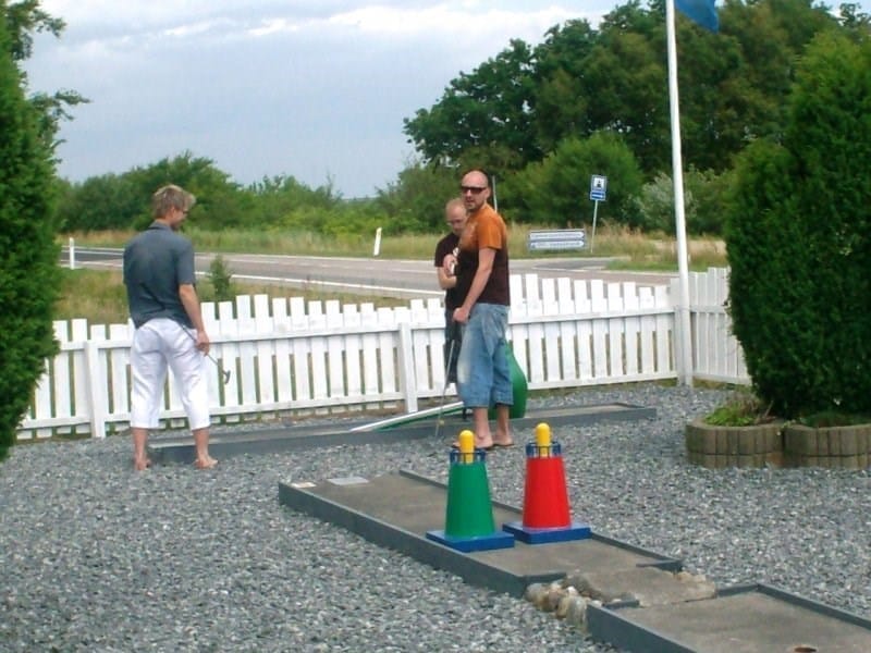 Folk spiller minigolf på udendørs bane