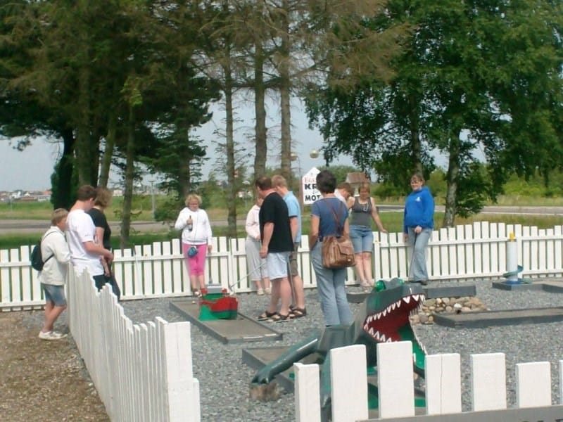Folk spiller minigolf udendørs en sommerdag