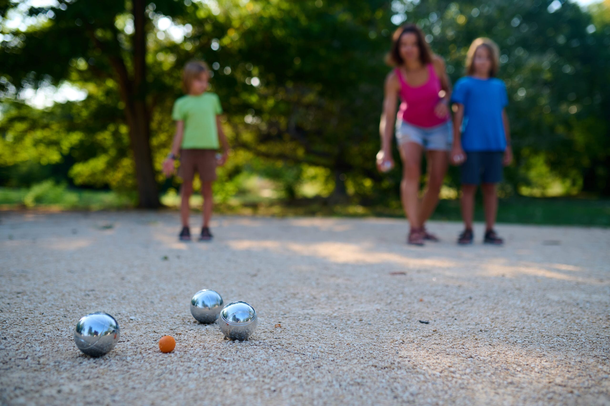 Familie spiller petanque i parken