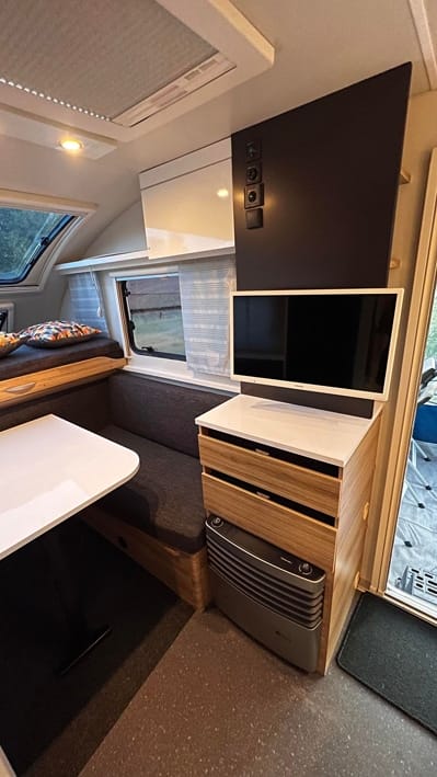 Moderne campingvogn med tv og siddeområde