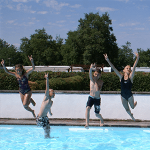 Børn hopper glade i swimmingpool om sommeren