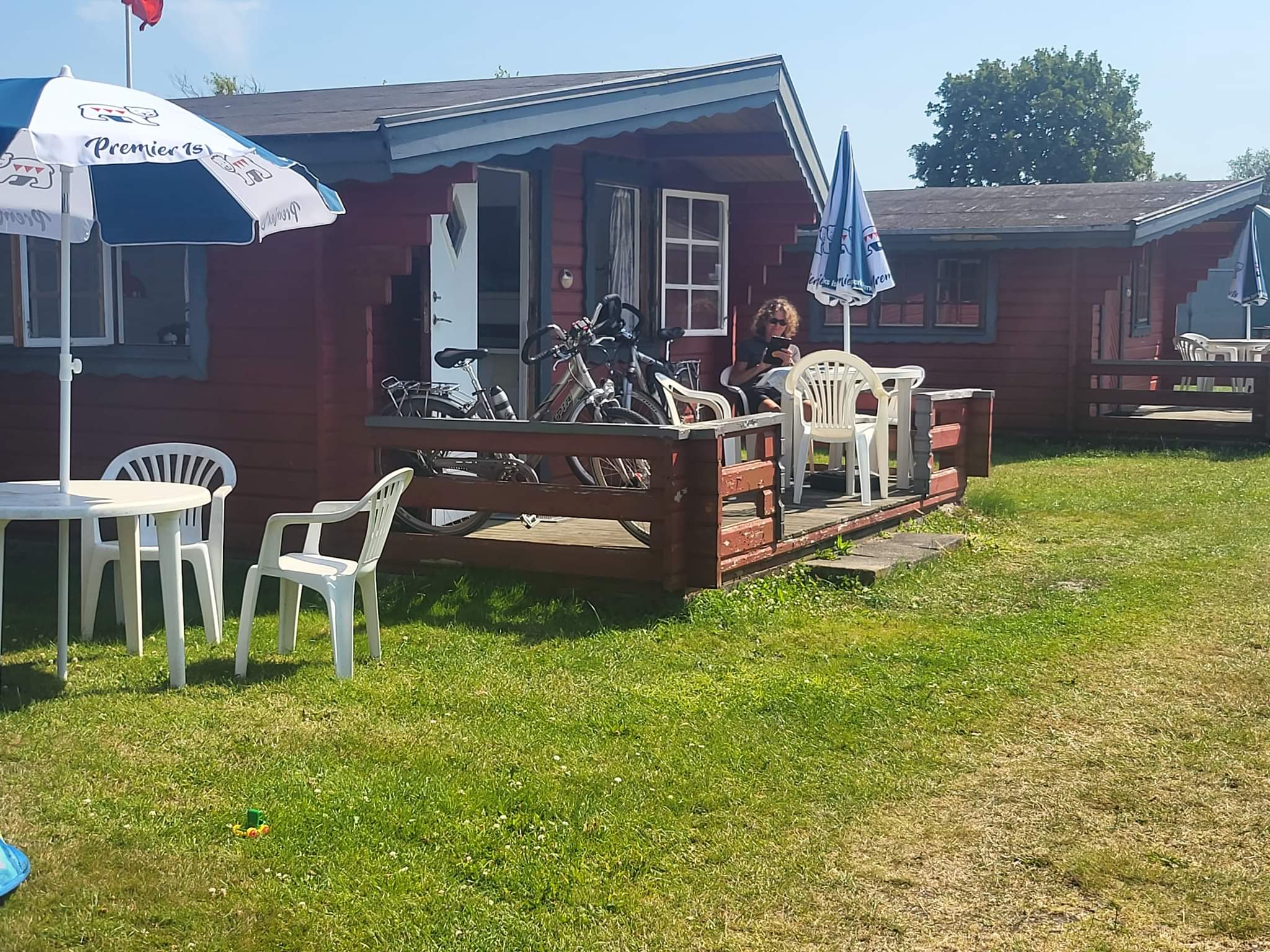 Røde feriehytter med terrasser og cykler i solen