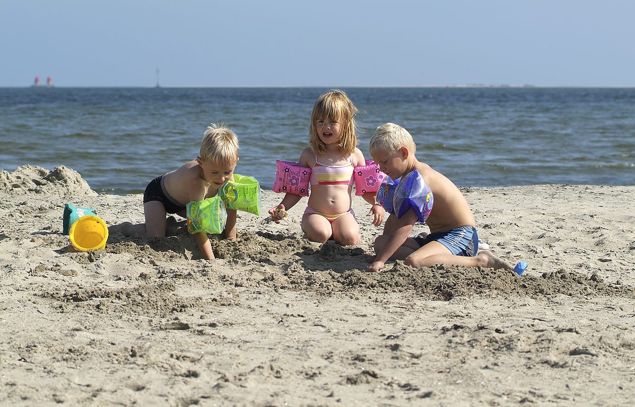 Børn leger i sandet på stranden